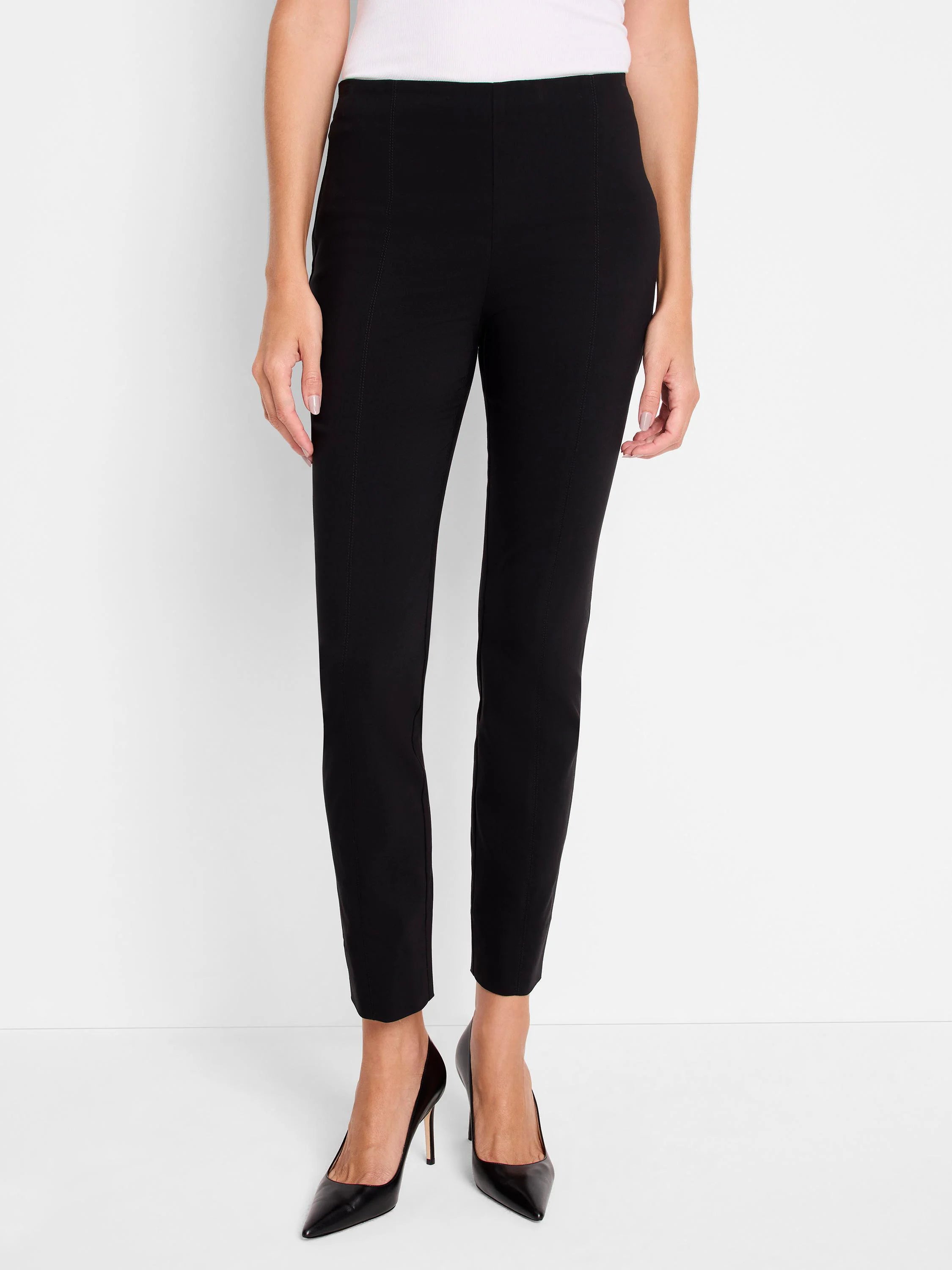 Black pull-on pants, slim fit, cropped length. Vertical seams at sides. Model wearing black heels.