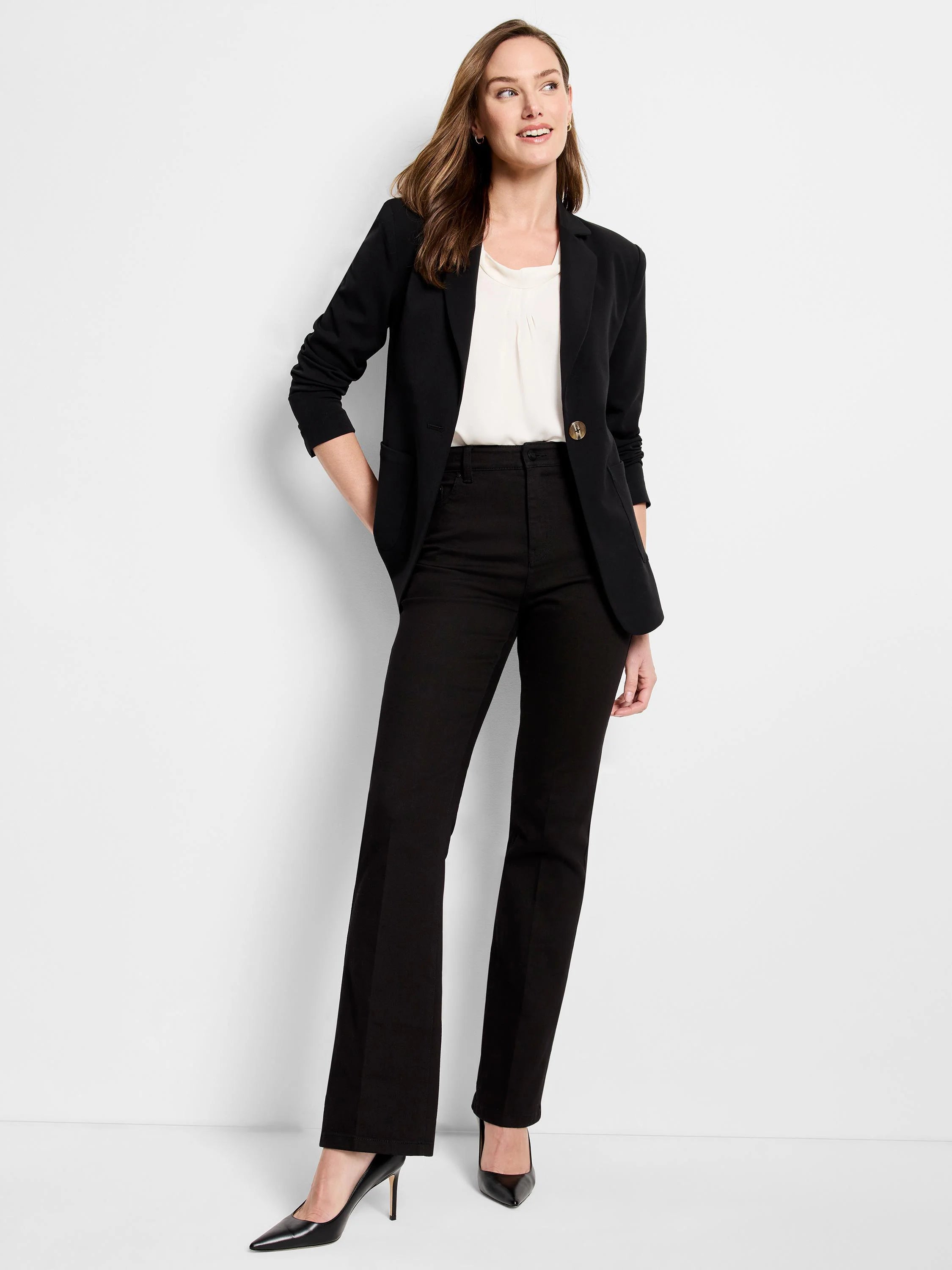 Black, high-rise bootcut jeans on a model. Slight flare at the ankle.