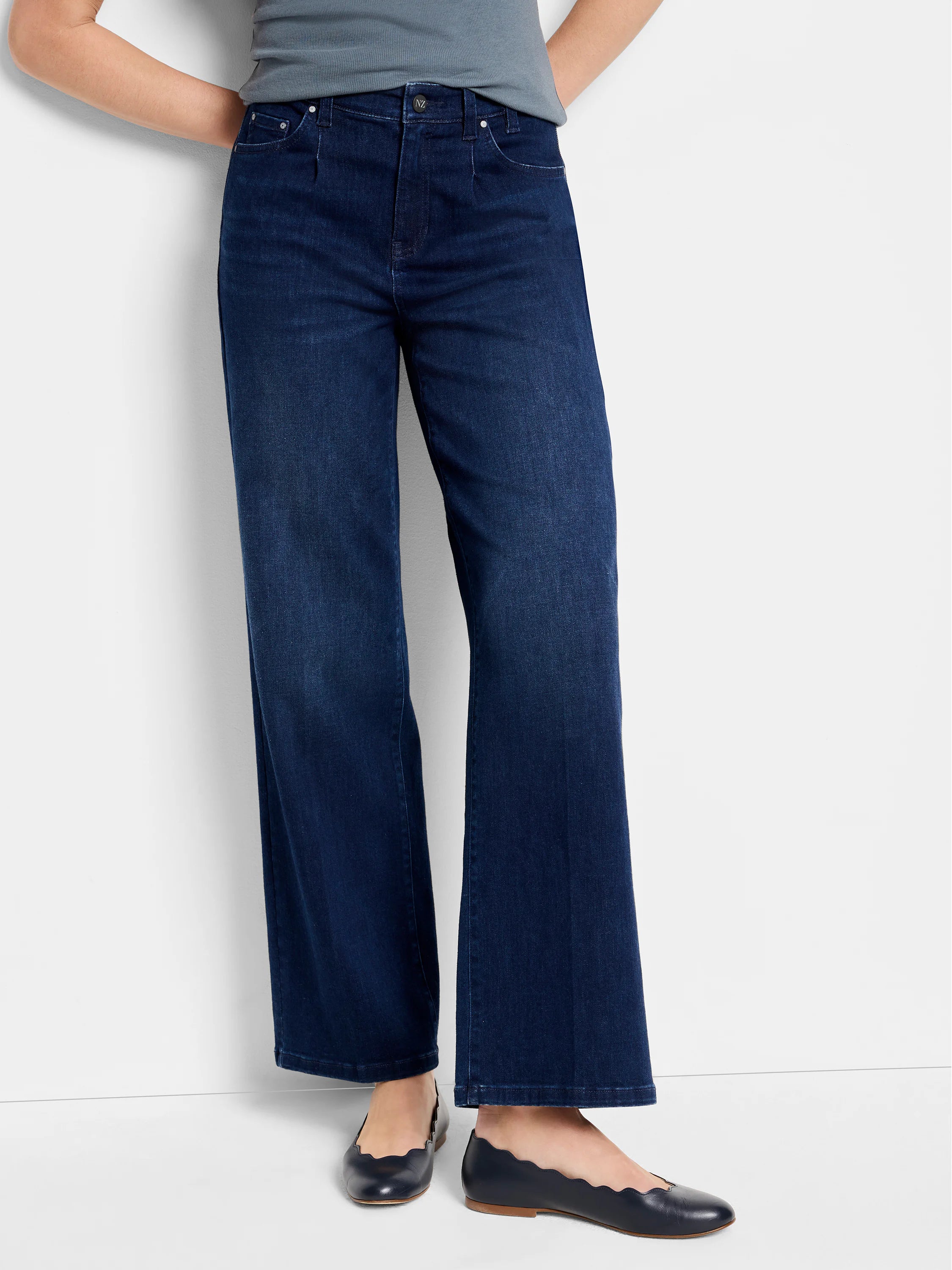 Dark wash, wide-leg jeans shown on model. The jeans are a dark blue. The model is wearing dark blue flats.