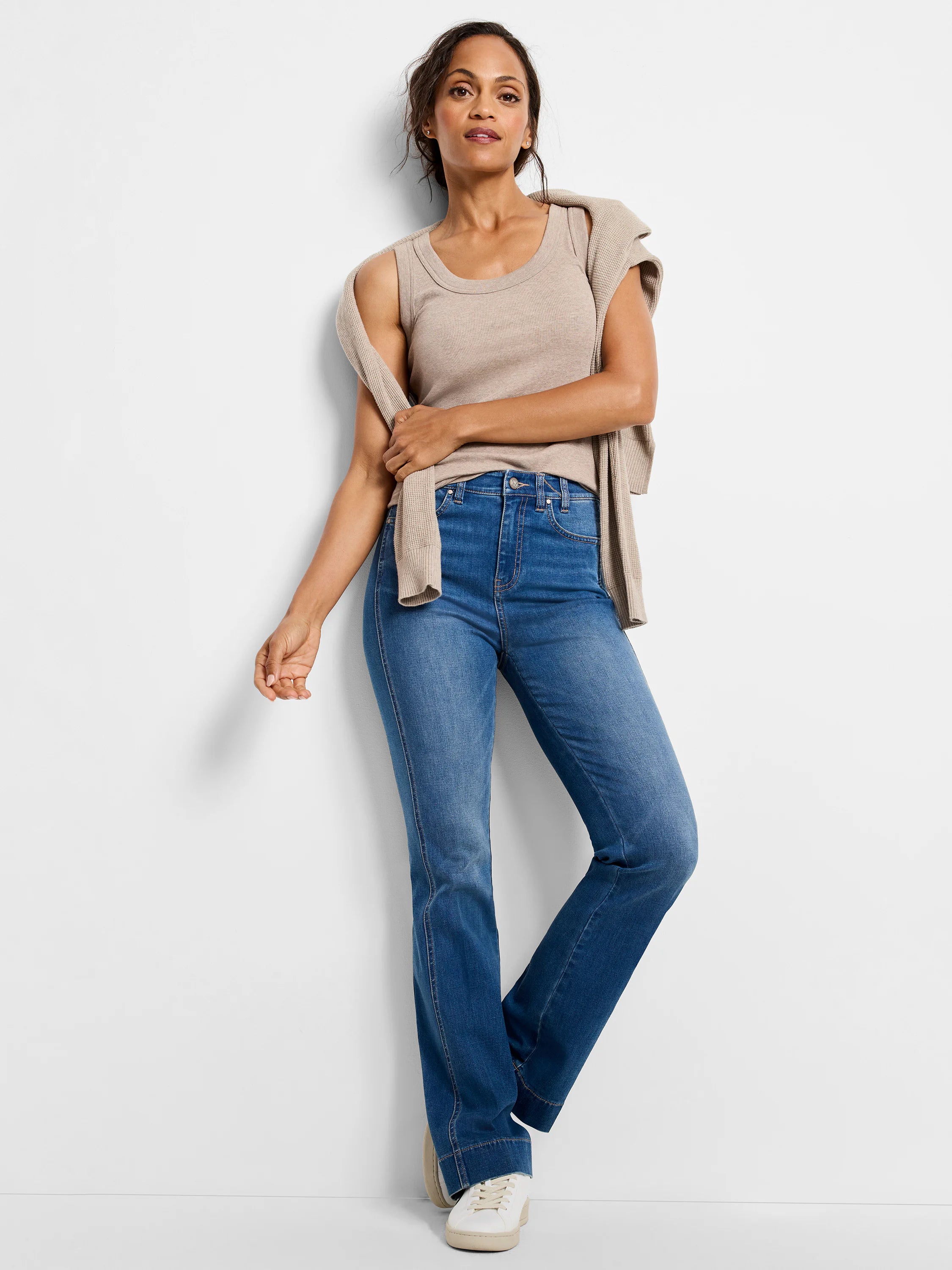 Blue, medium wash bootcut jeans with visible side panel seams.