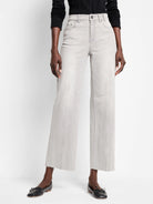 Light grey, wide-leg, cropped jeans with raw frayed hems.