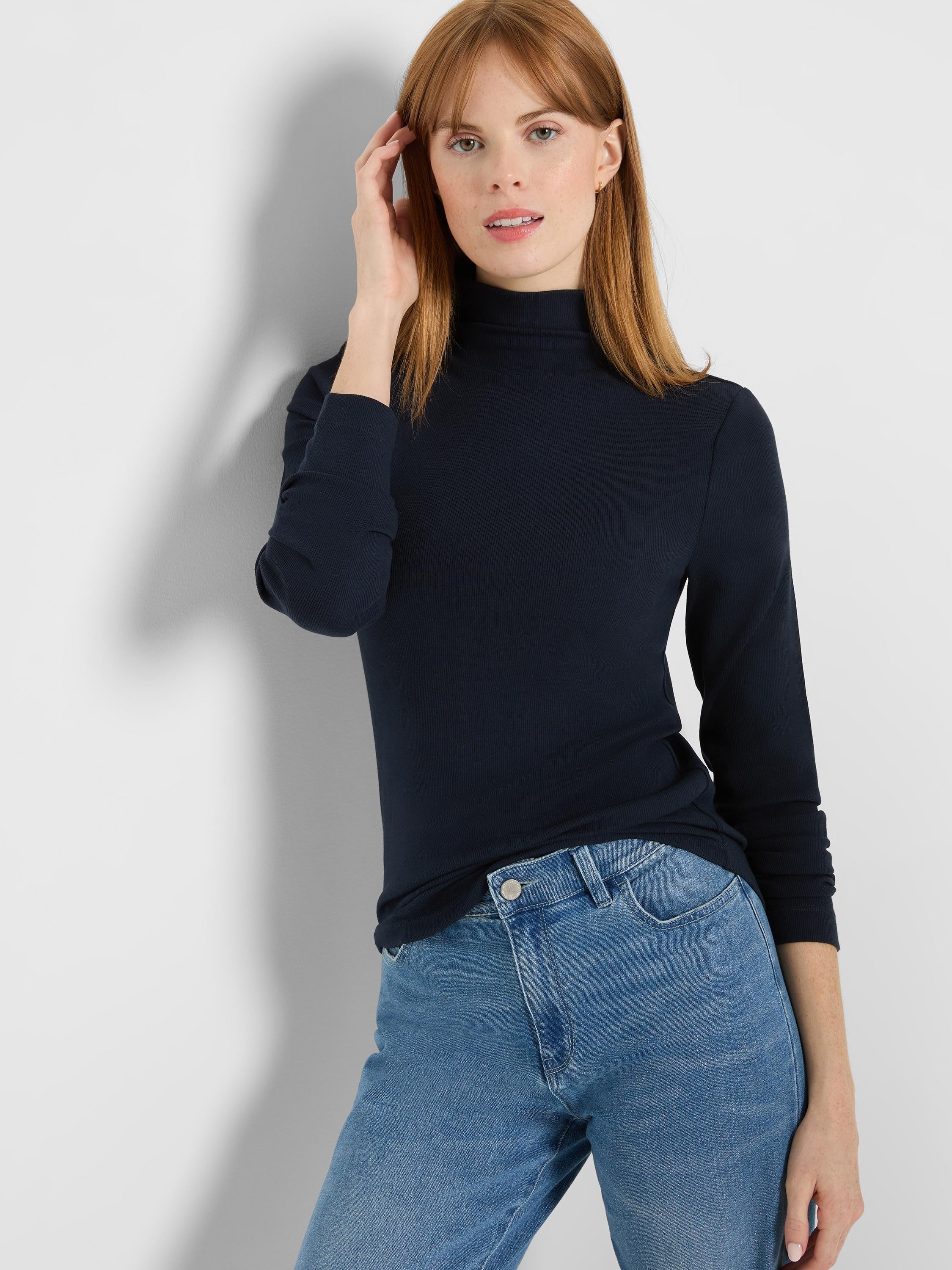 Slim-fit navy blue ribbed long-sleeve mock neck tee, worn by a woman.