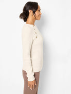 Cream waffle knit thermal top with gold buttons on the left shoulder.