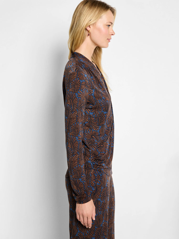 Long-sleeve wrap top with brown feather fern pattern on a blue background.