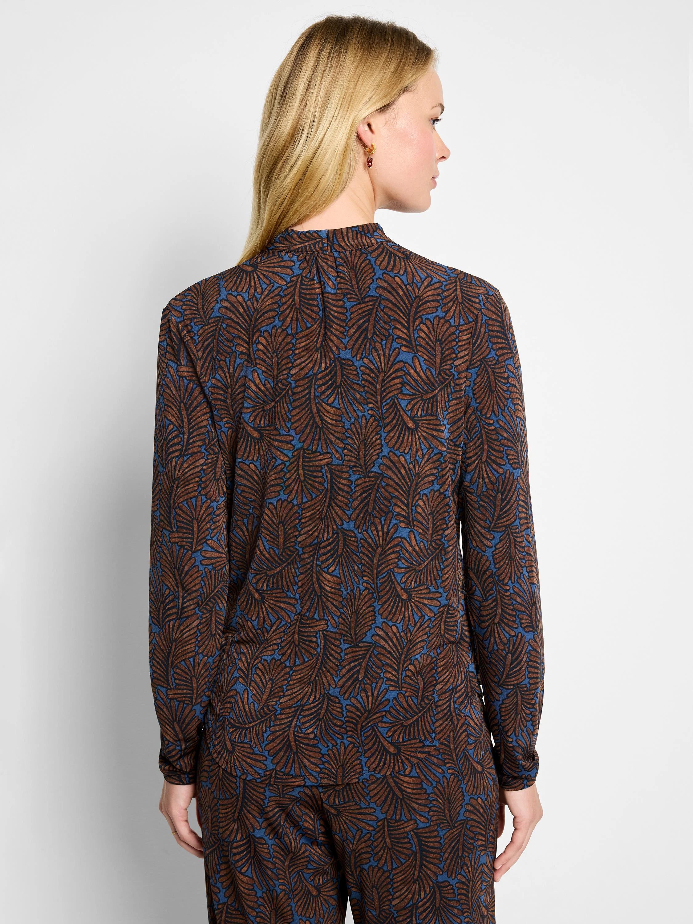 Long-sleeved top with brown and black feather fern pattern on a blue background.