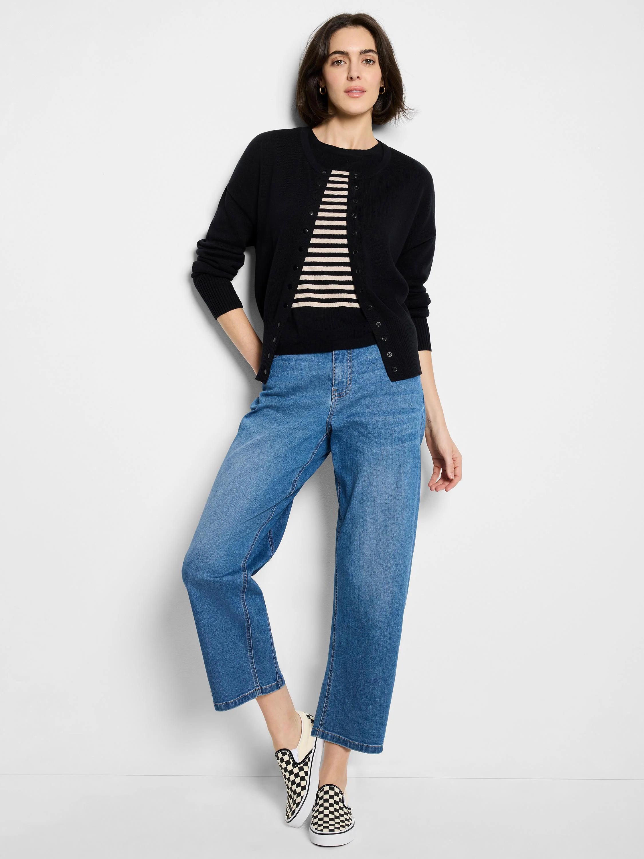 Black snap-front crew neck cardigan, worn open over a striped top.