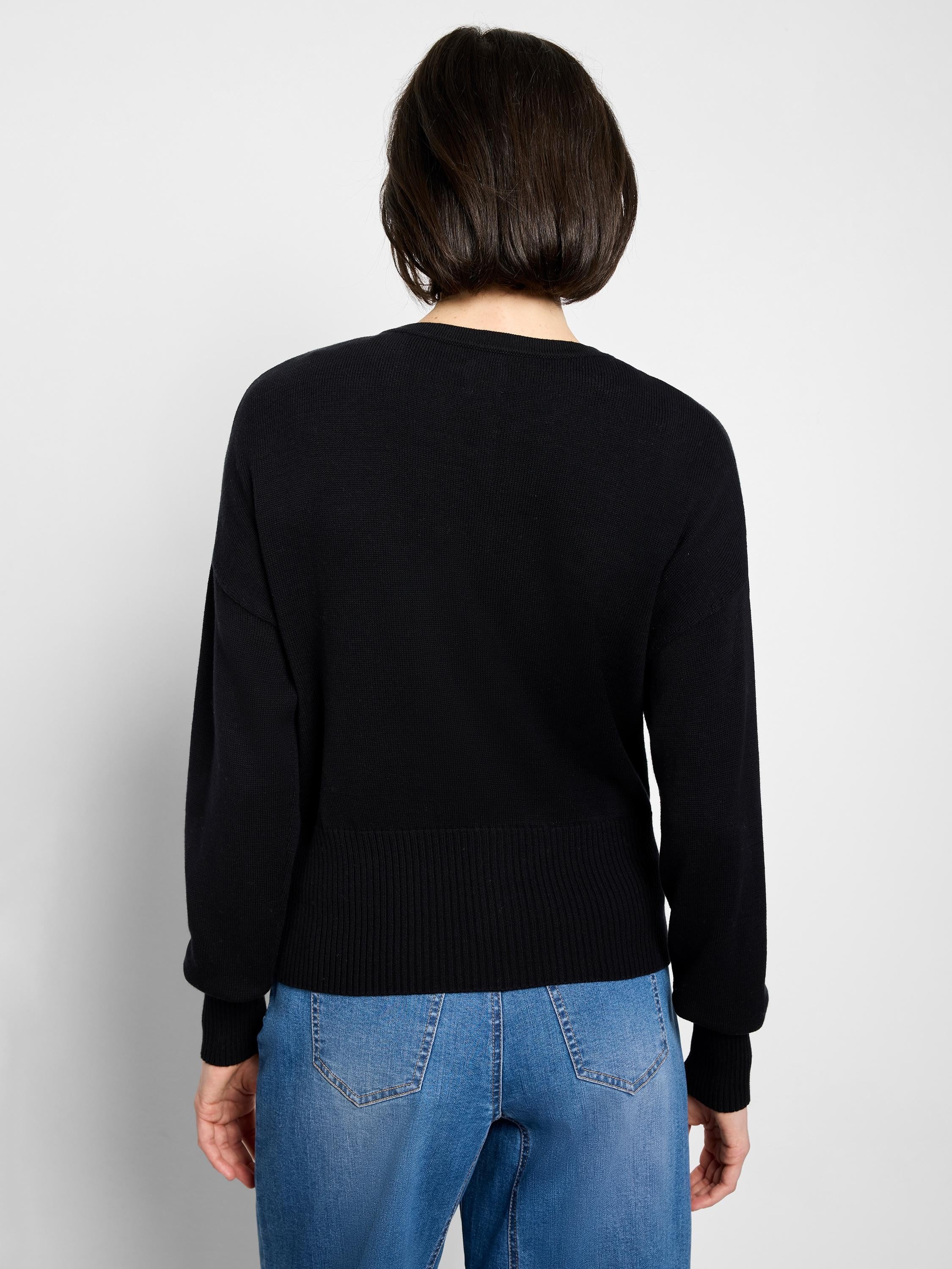 Back view of a black pure cotton cardigan. It features a fine knit body with ribbed cuffs and hem.
