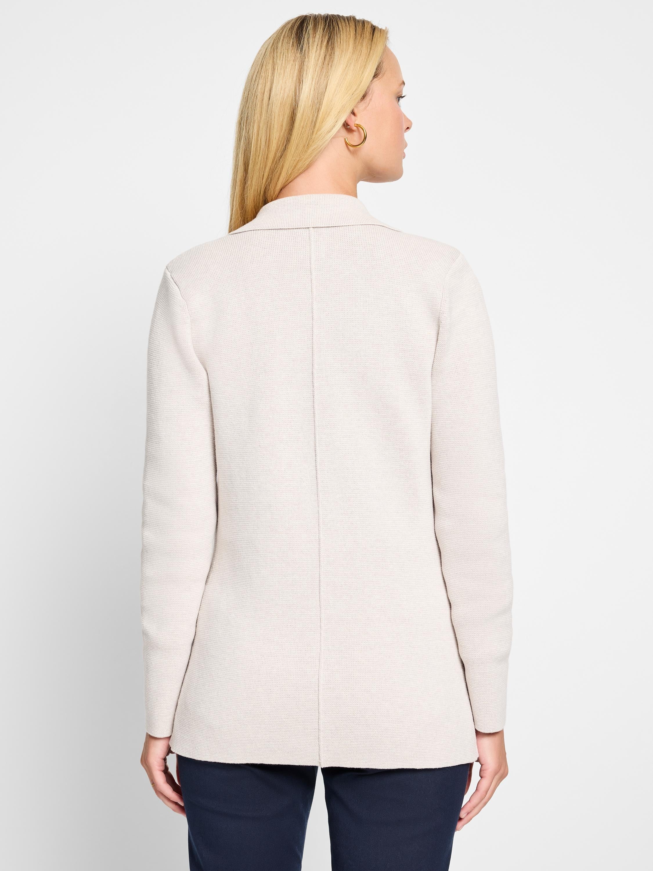 Back view of a light beige knit blazer. Ribbed texture, collar, center back seam, mid-hip length.