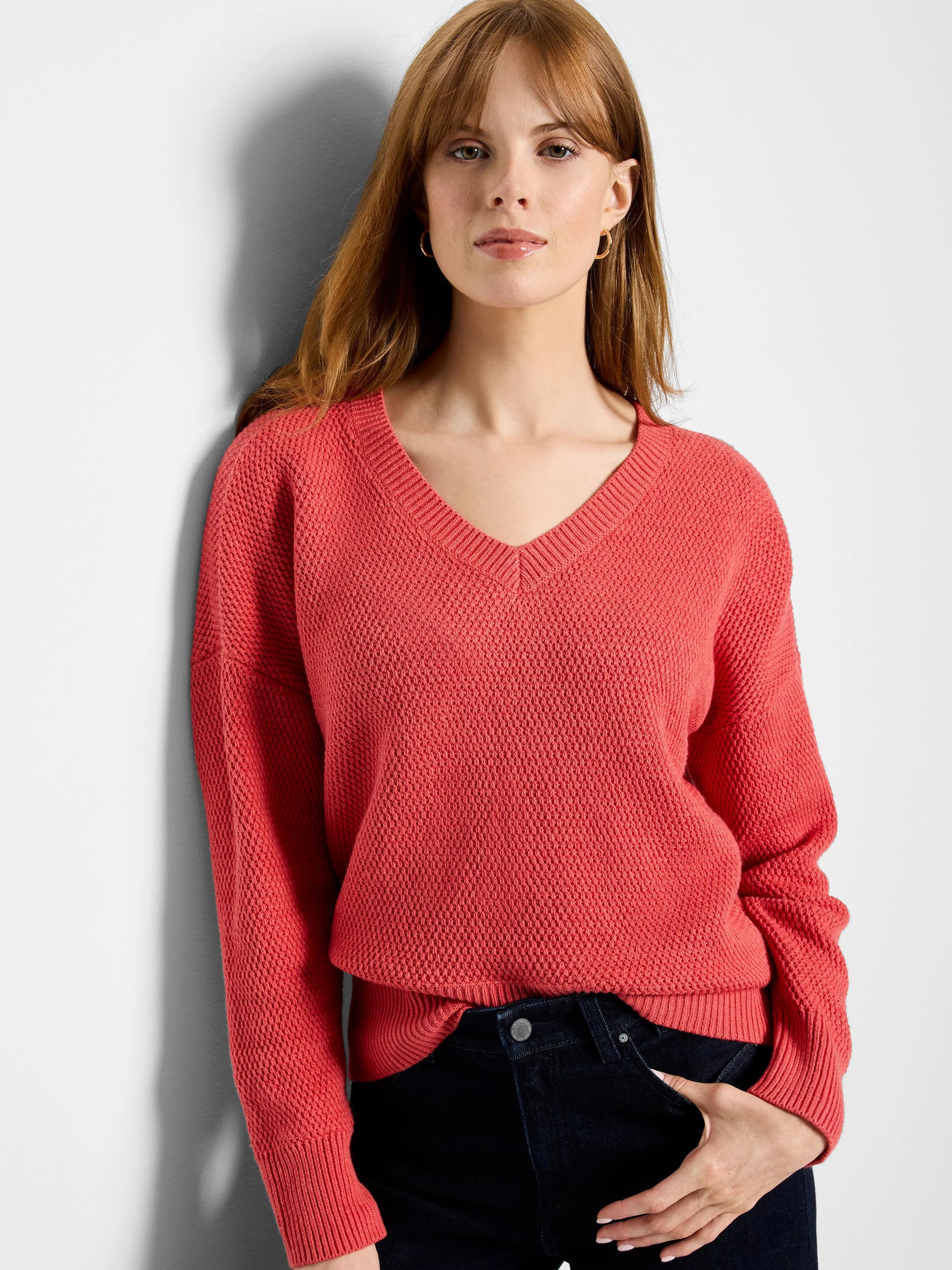 Reddish-orange V-neck sweater with a distinct tuck stitch knit texture, ribbed cuffs and hem.