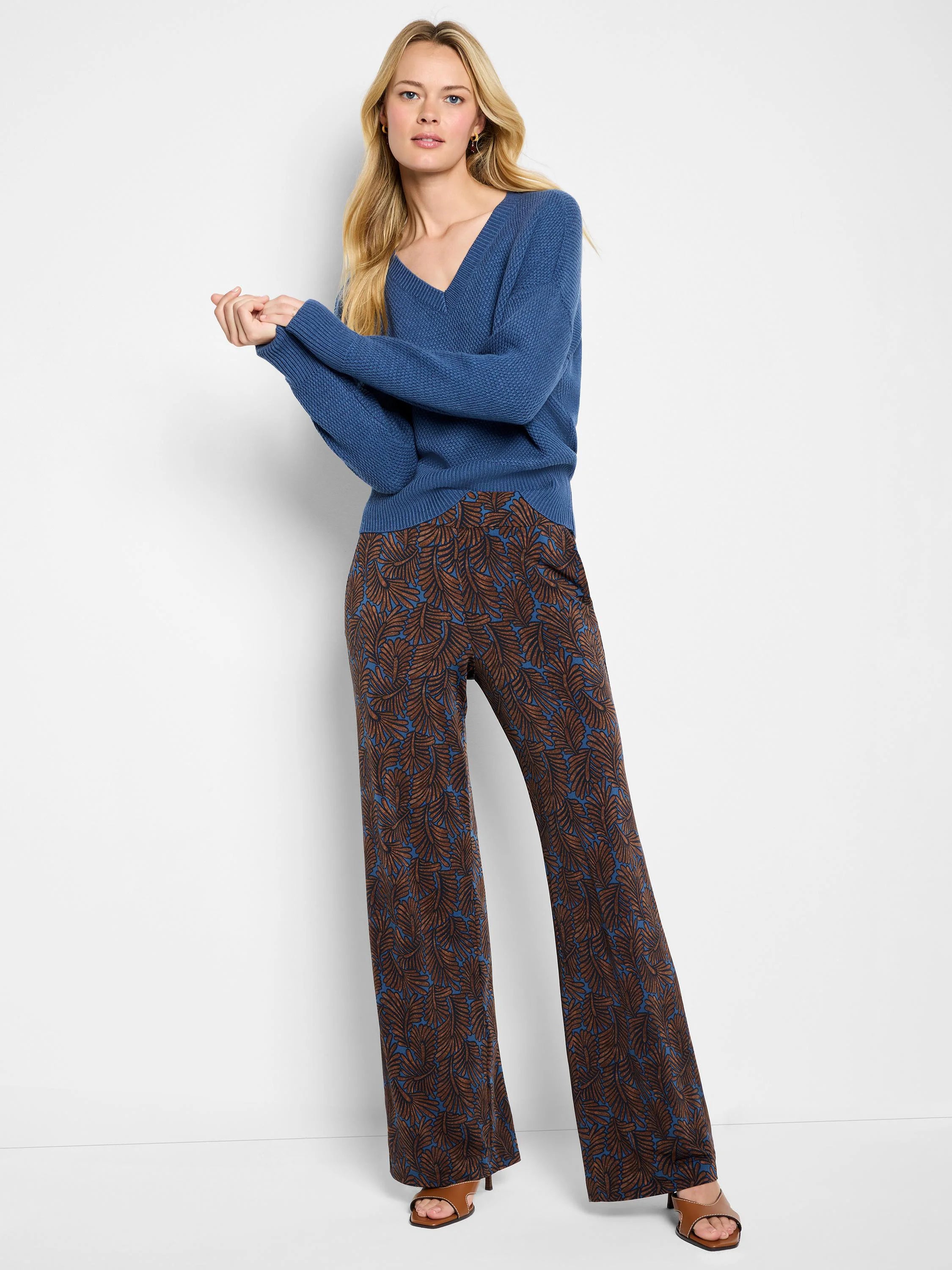 Dusty blue V-neck sweater with visible tuck stitch texture and long sleeves.