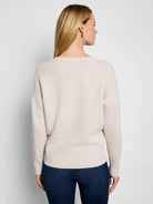 Oatmeal tuck stitch sweater, back view, with a round neck, dropped shoulders, and ribbed cuffs/hem.