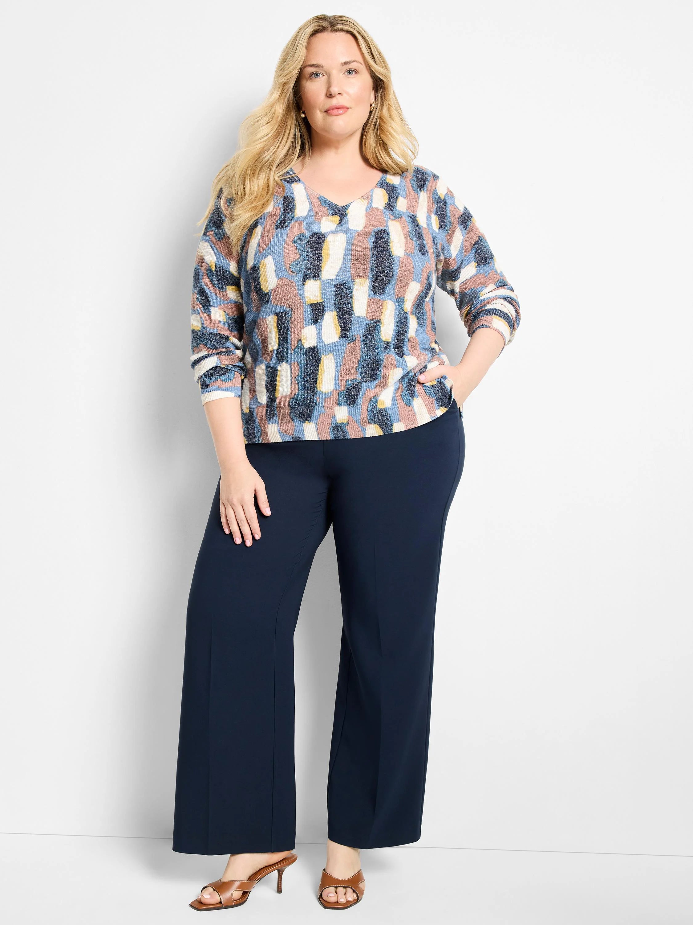 V-neck sweater with abstract blue, brown, yellow, and cream pattern. Features ribbed cuffs & hem.