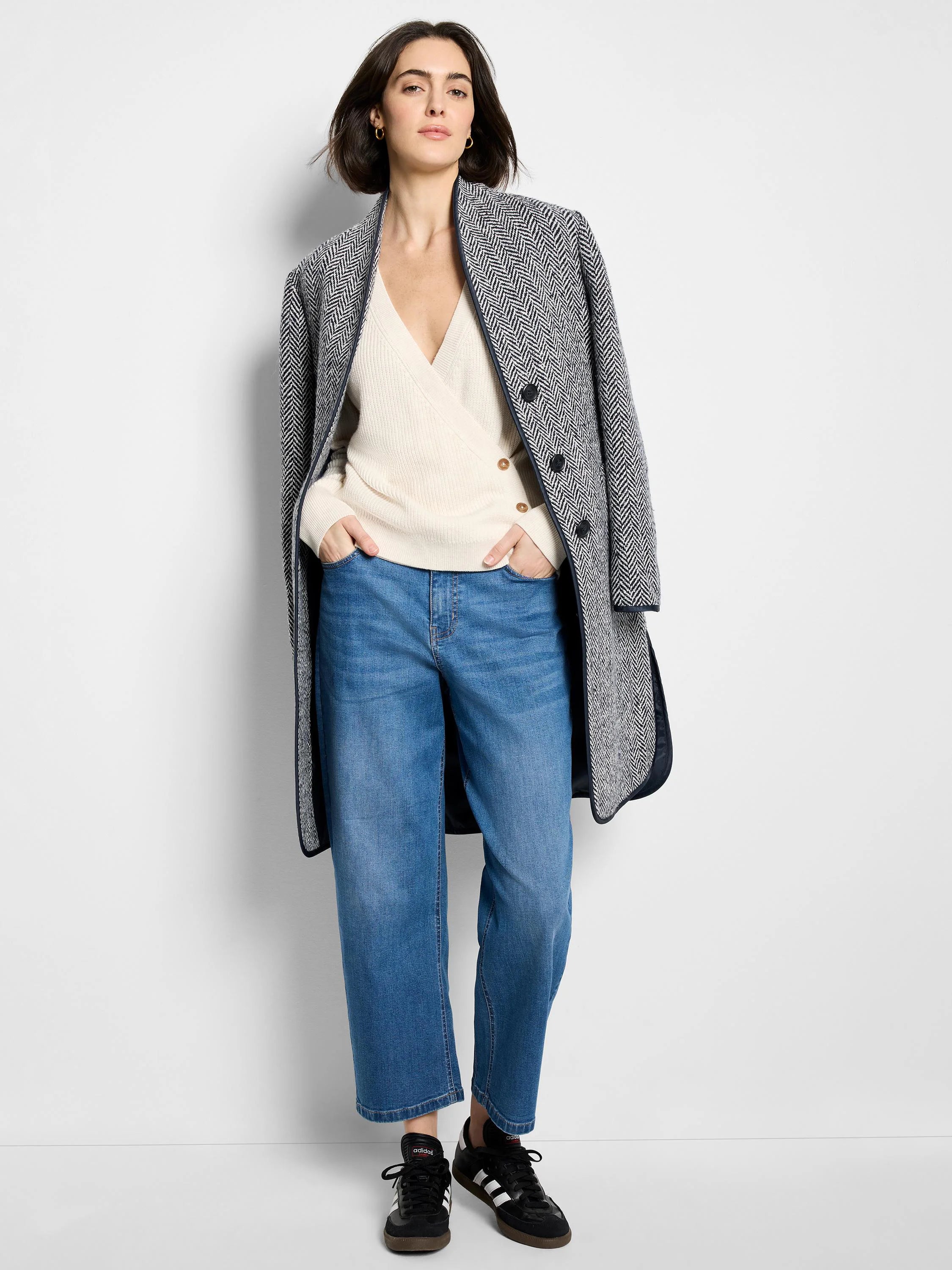 Cream shaker stitch wrap sweater with a V-neck and light brown buttons on the wrapped side.