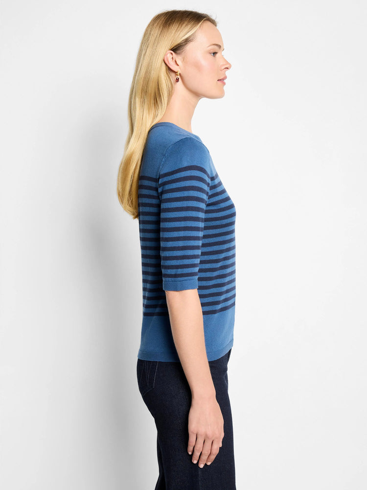 Light and dark blue horizontally striped sweater tee with three-quarter sleeves worn by a model in profile.