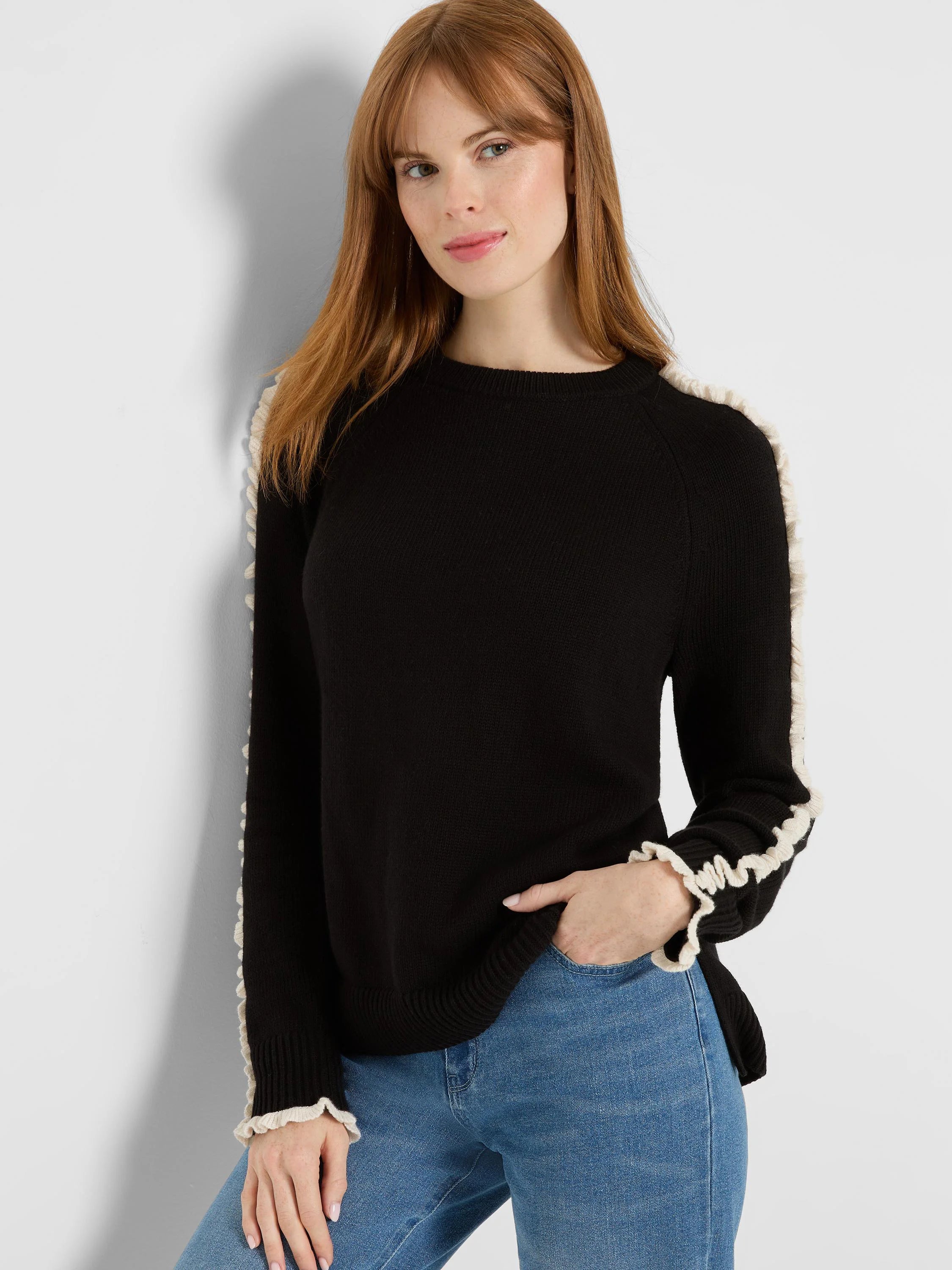 Black crew neck sweater with cream ruffles on the shoulders, down the sleeves, and at the cuffs.