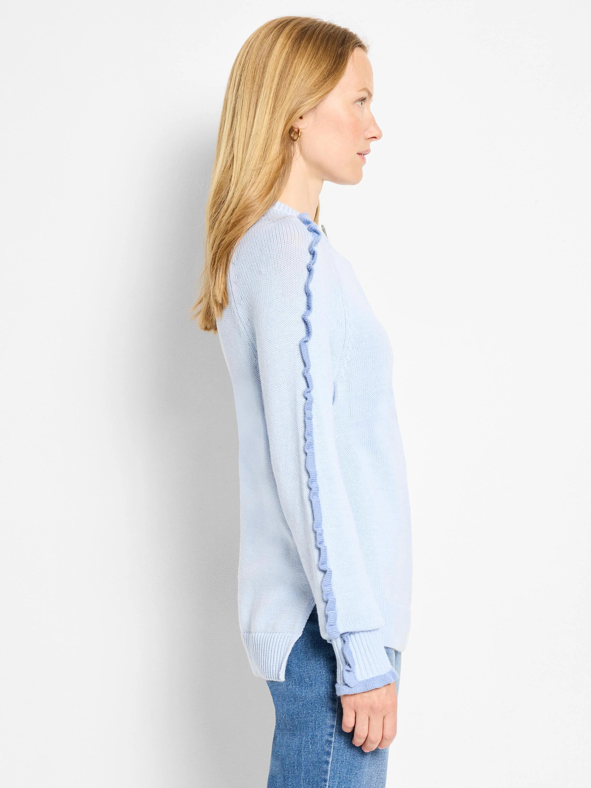 Pale blue knit sweater with darker blue ruffles on sleeve seams and cuffs.