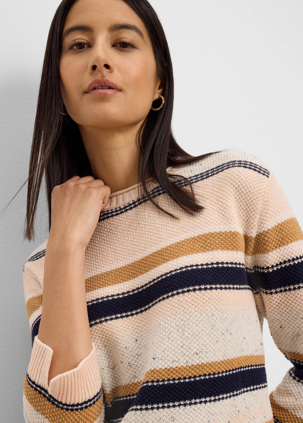 Knit sweater with horizontal stripes in cream, pale peach, navy, and mustard yellow.