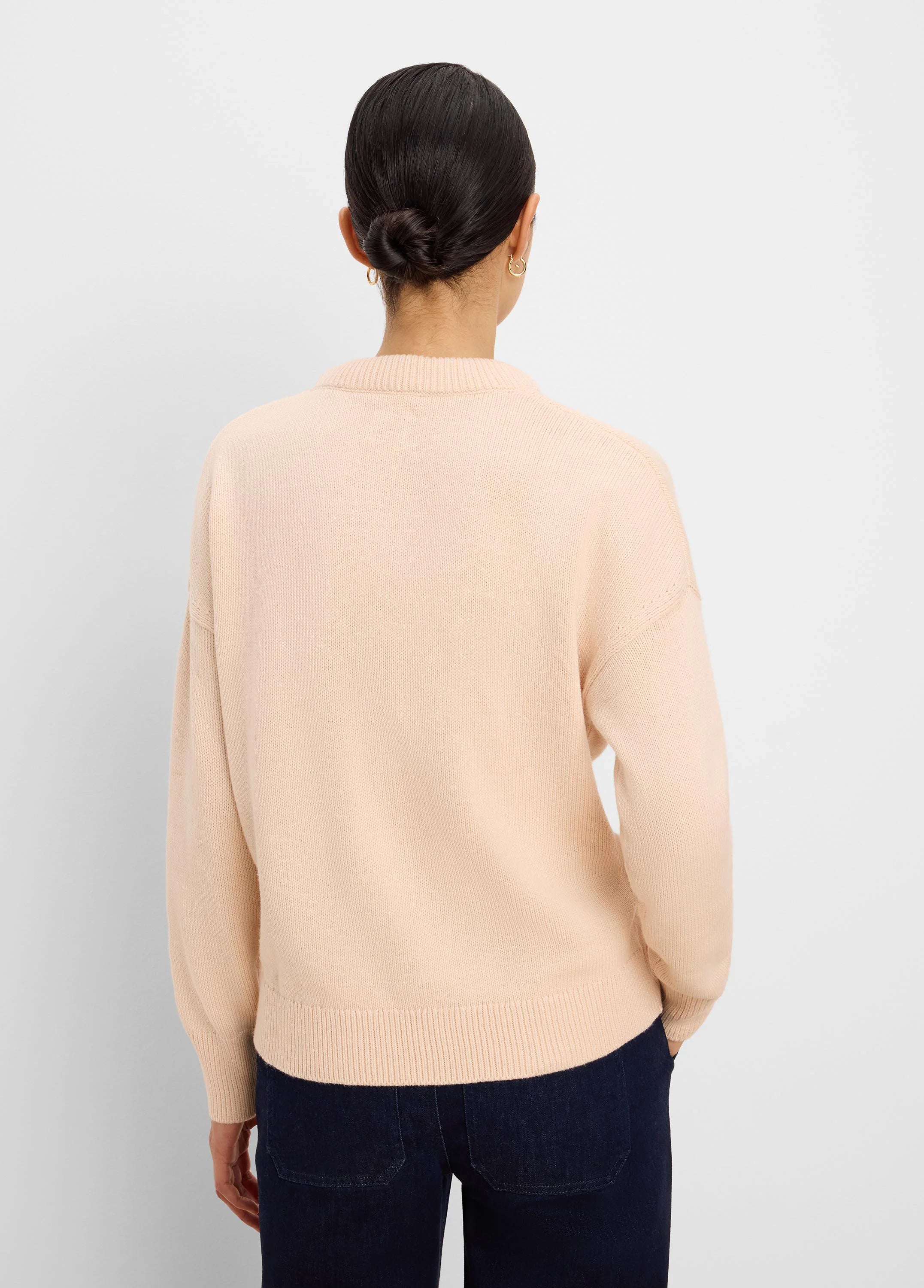 Light peach cotton cashmere sweater, back view, with ribbed neck, cuffs, and hem, loose fit.