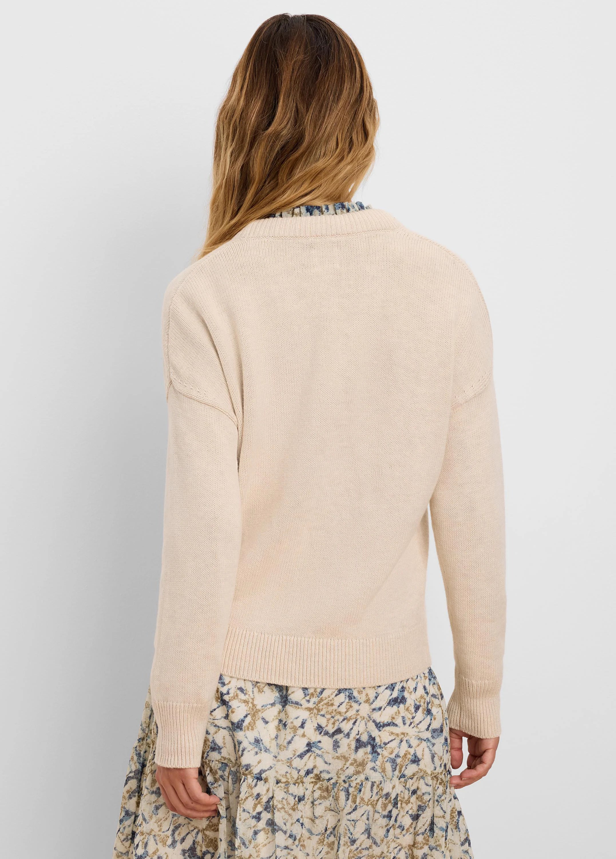 Light beige cotton cashmere sweater, back view. Shows knit texture, ribbed cuffs, hem, and back collar.