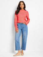 Red-orange sweater with textured dot pattern at the neckline and cuffs.