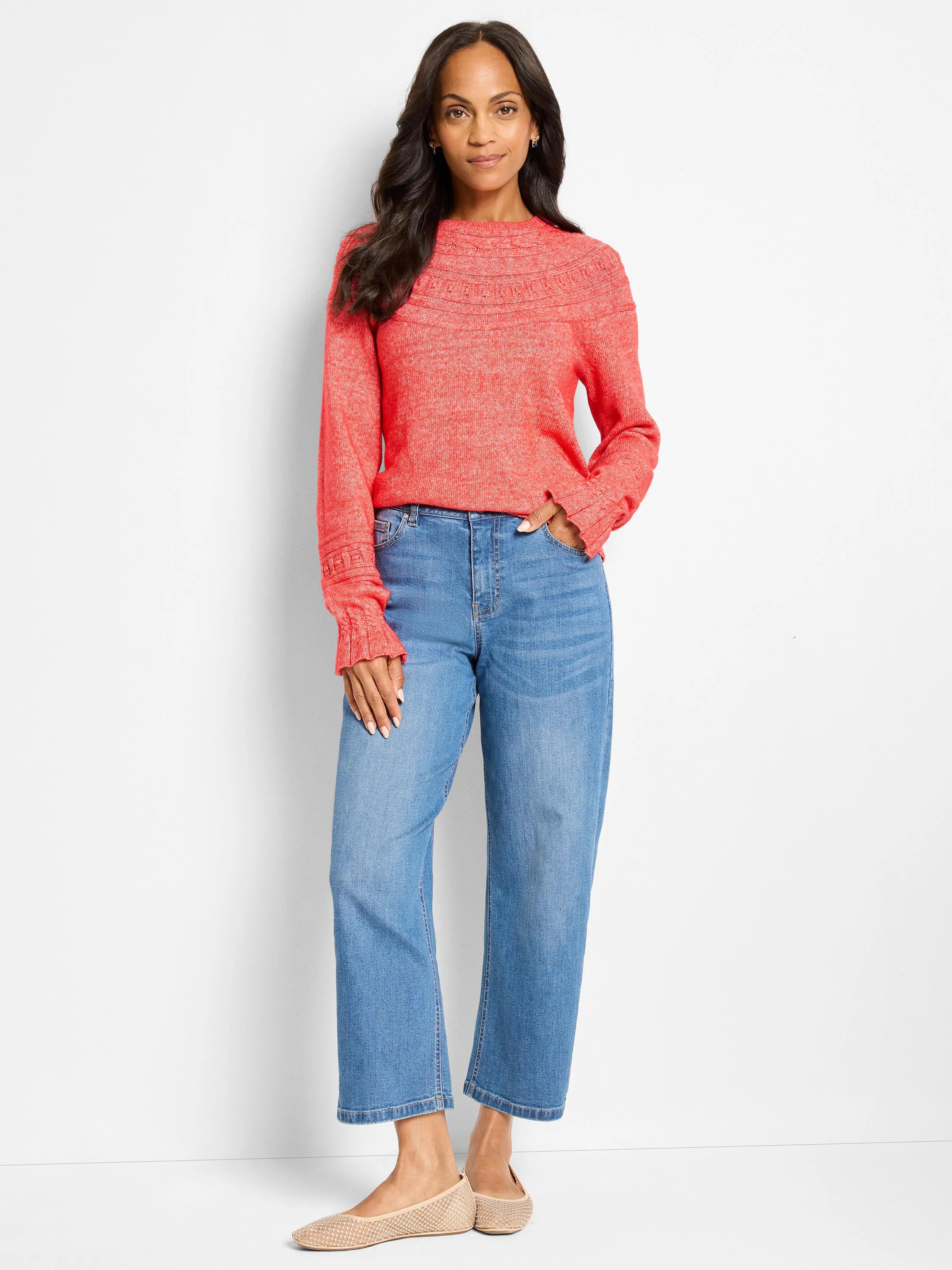 Red-orange sweater with textured dot pattern at the neckline and cuffs.