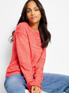 Heather coral crewneck sweater with textural dot knit pattern on neckline and cuffs.