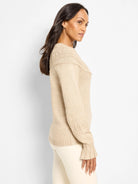 Oatmeal sweater with raised dot patterns on shoulders & sleeves, ribbed hem, & ruffled cuffs.