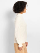 Off-white mock-neck sweater with an all-over raised diamond knit pattern.