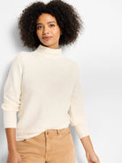 Cream mock-neck sweater with an all-over raised diamond pattern. Features ribbed cuffs.
