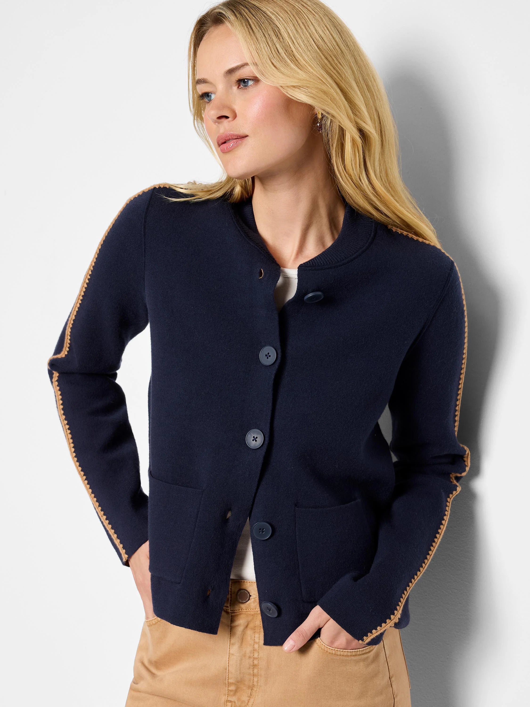 Navy knit bomber jacket with tan zig-zag trim on sleeves, collar, and hem. Features front button closure and pockets.