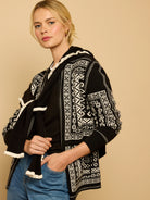 Black and off-white reversible hoodie jacket with geometric Nordic pattern, front zipper, and ribbed trim.