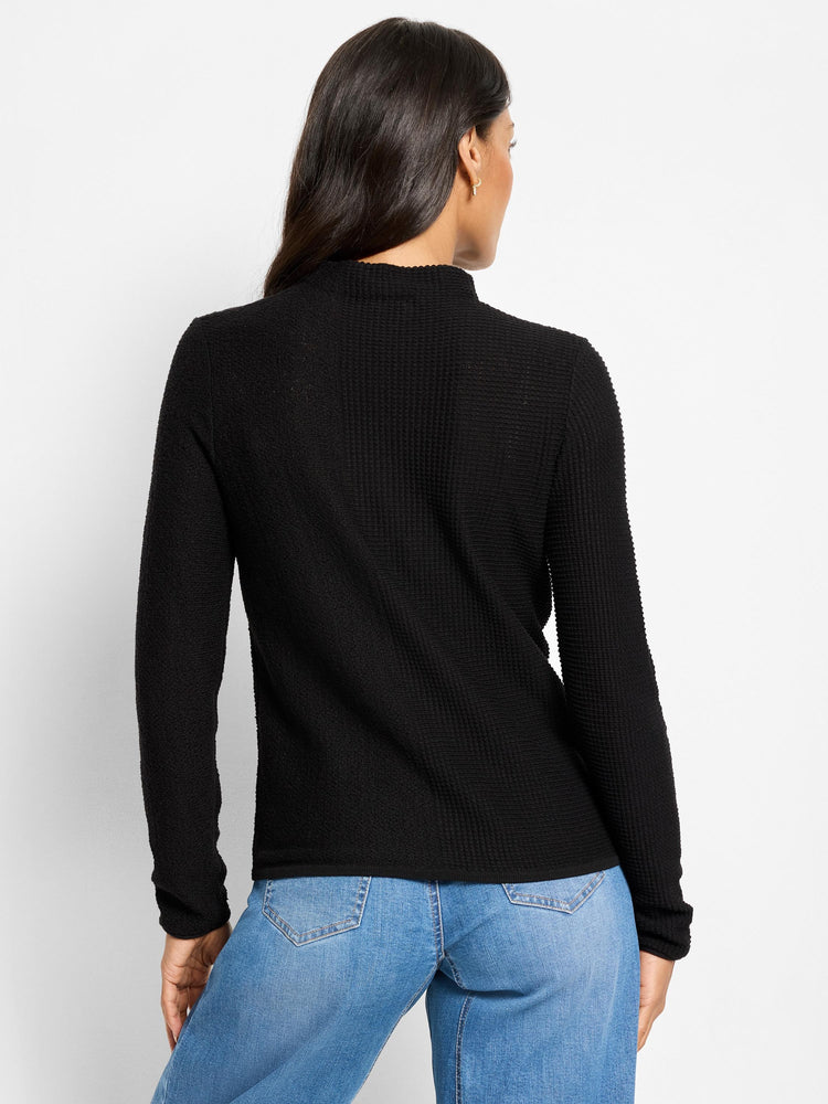 Black long-sleeve sweater with a textured pixel knit pattern and a mock neck, shown on a model from the back.