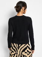 Black knit Cardy with subtle sparkle, viewed from back. Features open knit, ribbed crew neck, long sleeves, ribbed hem.