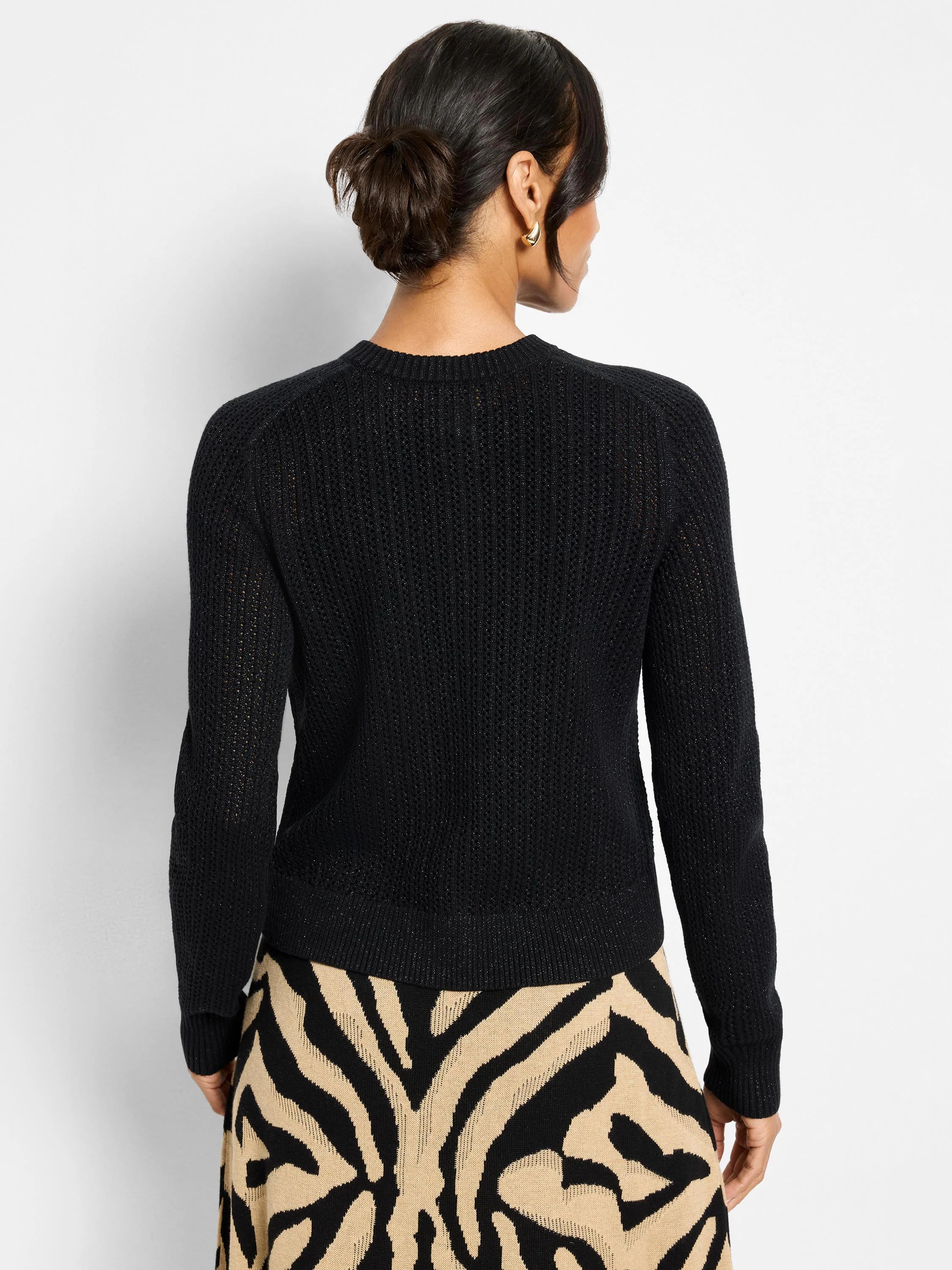 Black knit Cardy with subtle sparkle, viewed from back. Features open knit, ribbed crew neck, long sleeves, ribbed hem.
