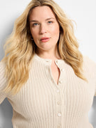 Cream open-knit cardigan with textured eyelet pattern, featuring a button-front.