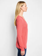 Coral pink waffle stitch V-neck sweater. Features a relaxed fit, long sleeves, and side slits.