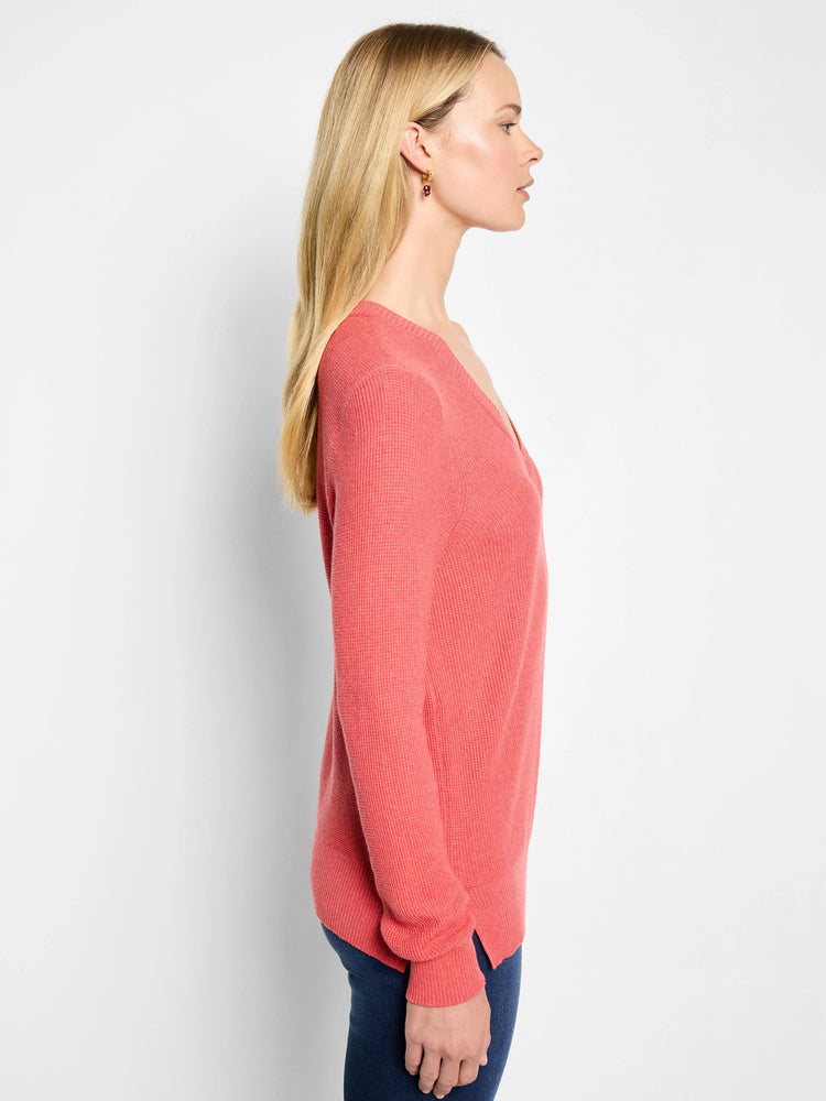 Coral pink waffle stitch V-neck sweater. Features a relaxed fit, long sleeves, and side slits.