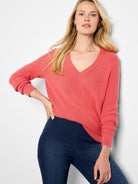 Coral pink waffle stitch V-neck sweater with ribbed trim.