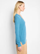 Blue waffle knit V-neck sweater. Features long sleeves and side slits at the hem.