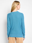Back view of a teal blue waffle stitch sweater with ribbed collar, cuffs, and hem.