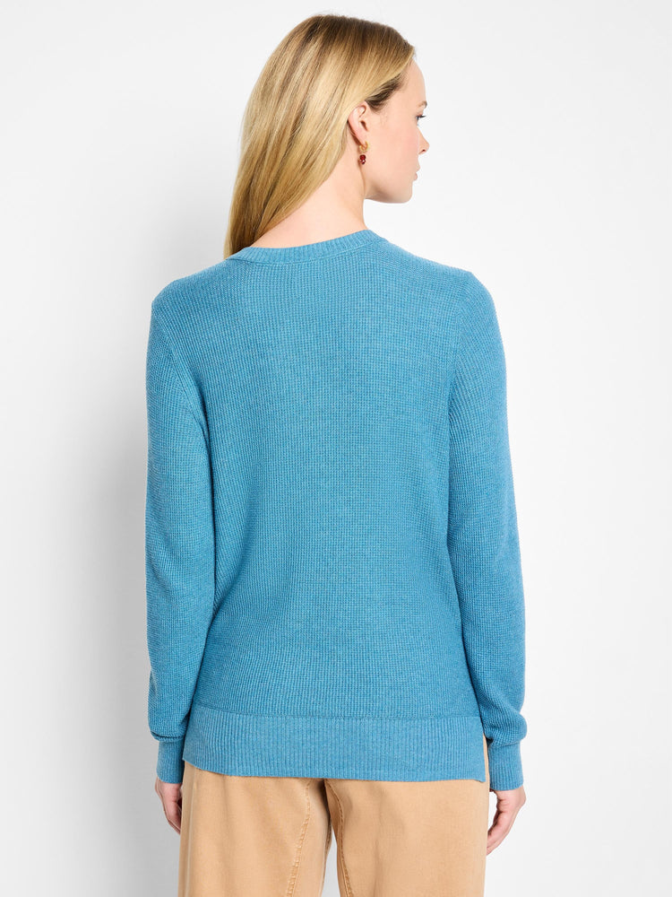 Back view of a teal blue waffle stitch sweater with ribbed collar, cuffs, and hem.