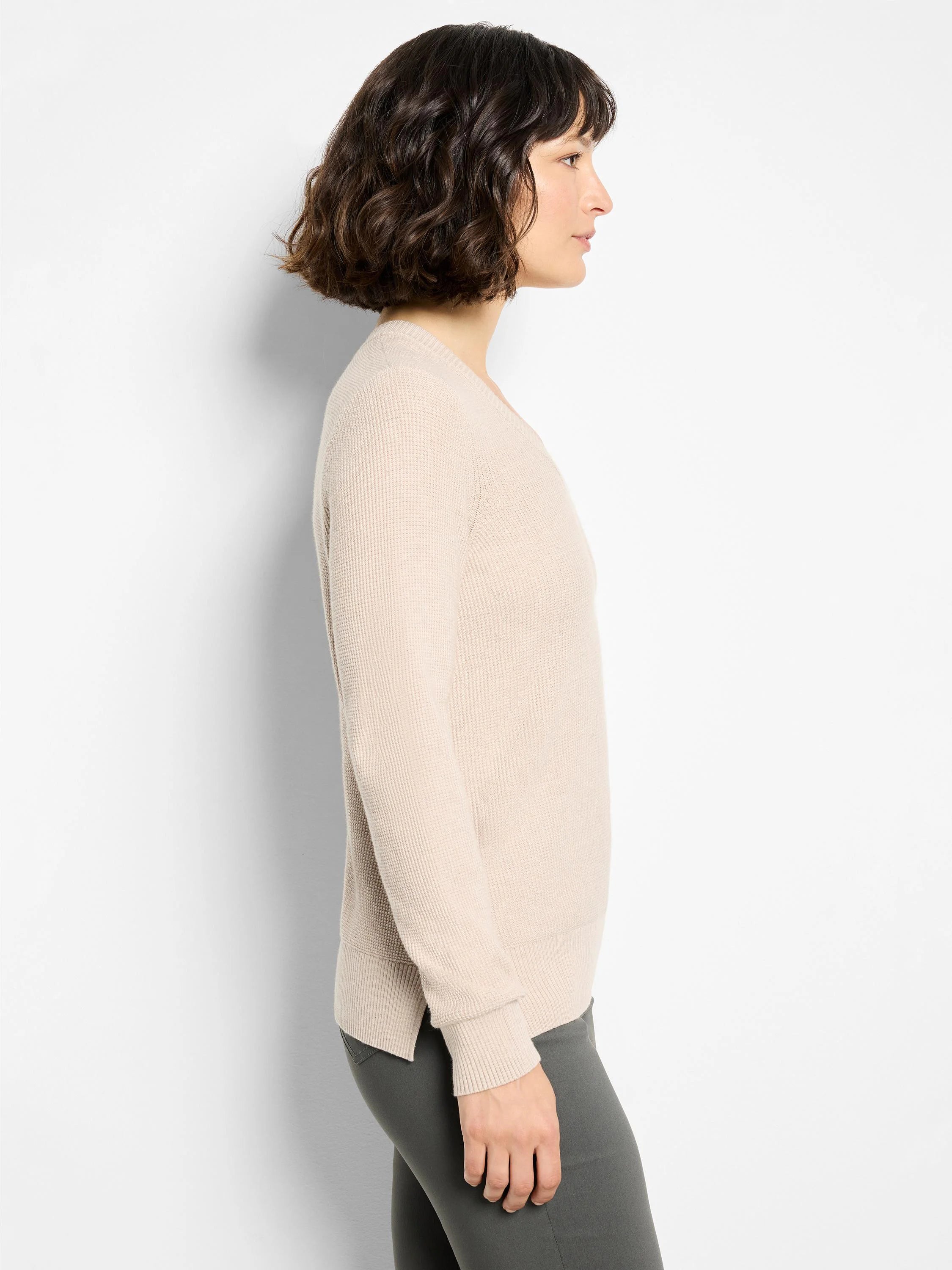 Light beige V-neck sweater with waffle stitch, long sleeves, ribbed cuffs and hem, shown on model.
