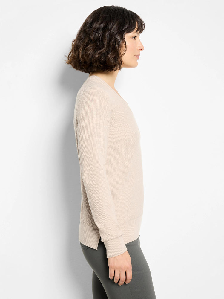 Light beige V-neck sweater with waffle stitch, long sleeves, ribbed cuffs and hem, shown on model.