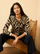 Black and tan zebra jacquard knit cardigan with a button-front closure.