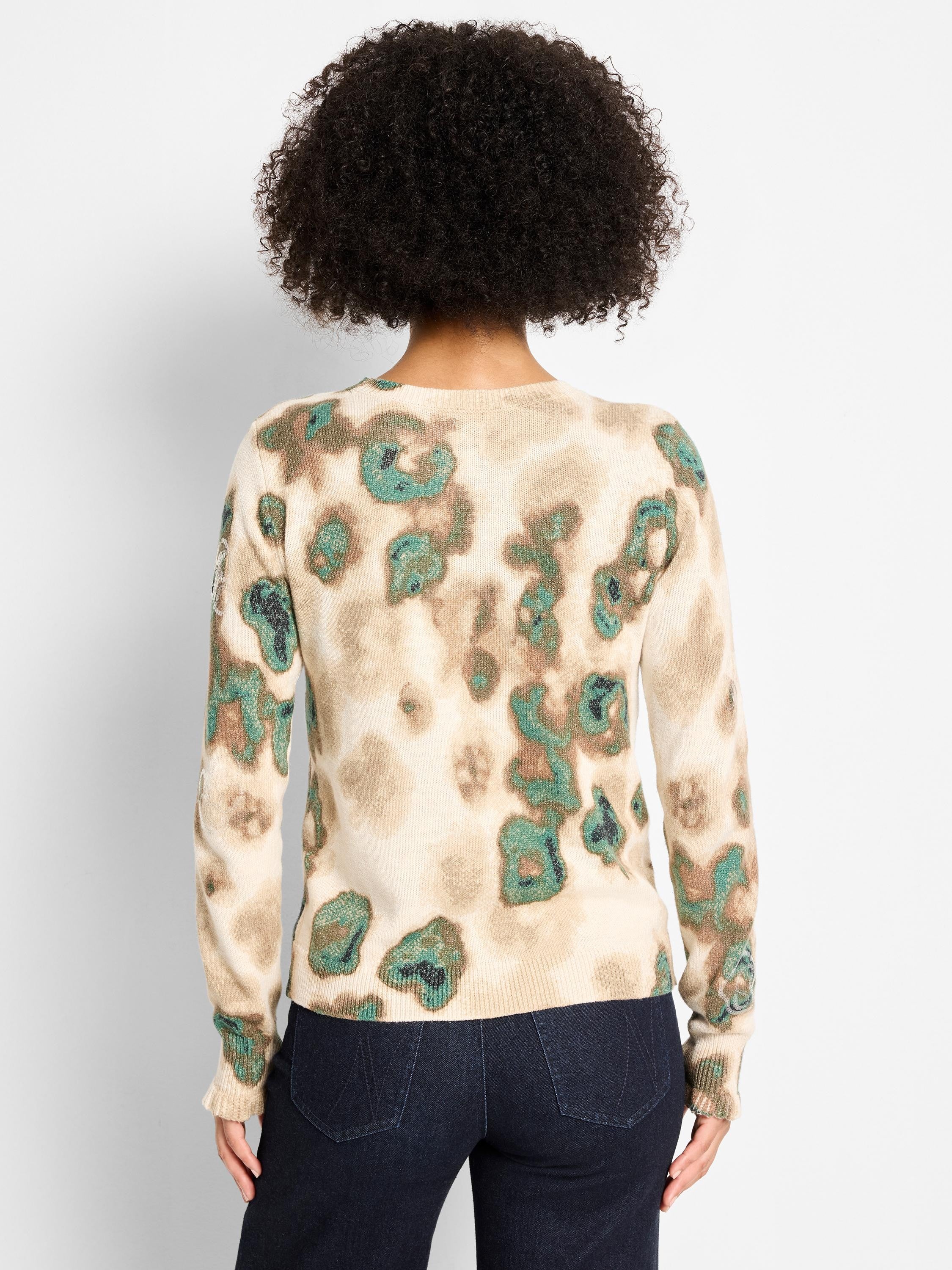 Beige knit sweater with shimmery green, brown, and tan camouflage pattern. Round neck, long sleeves.