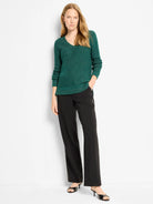 Deep green V-neck sweater with a waffle knit texture and subtle silver shimmer.