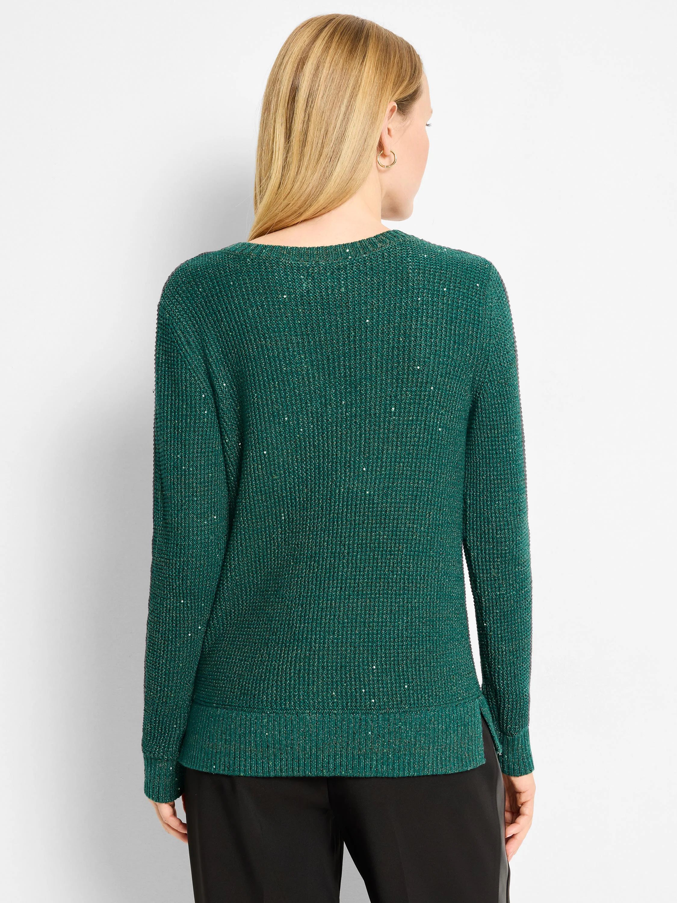 Emerald green waffle knit sweater, back view. Shimmers with metallic flecks. Has a rounded neckline and ribbed hem with...