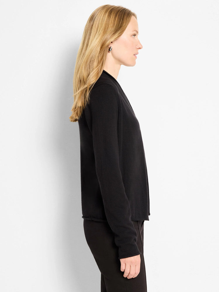 Black open-front cardigan with long sleeves, shown in profile on a woman.