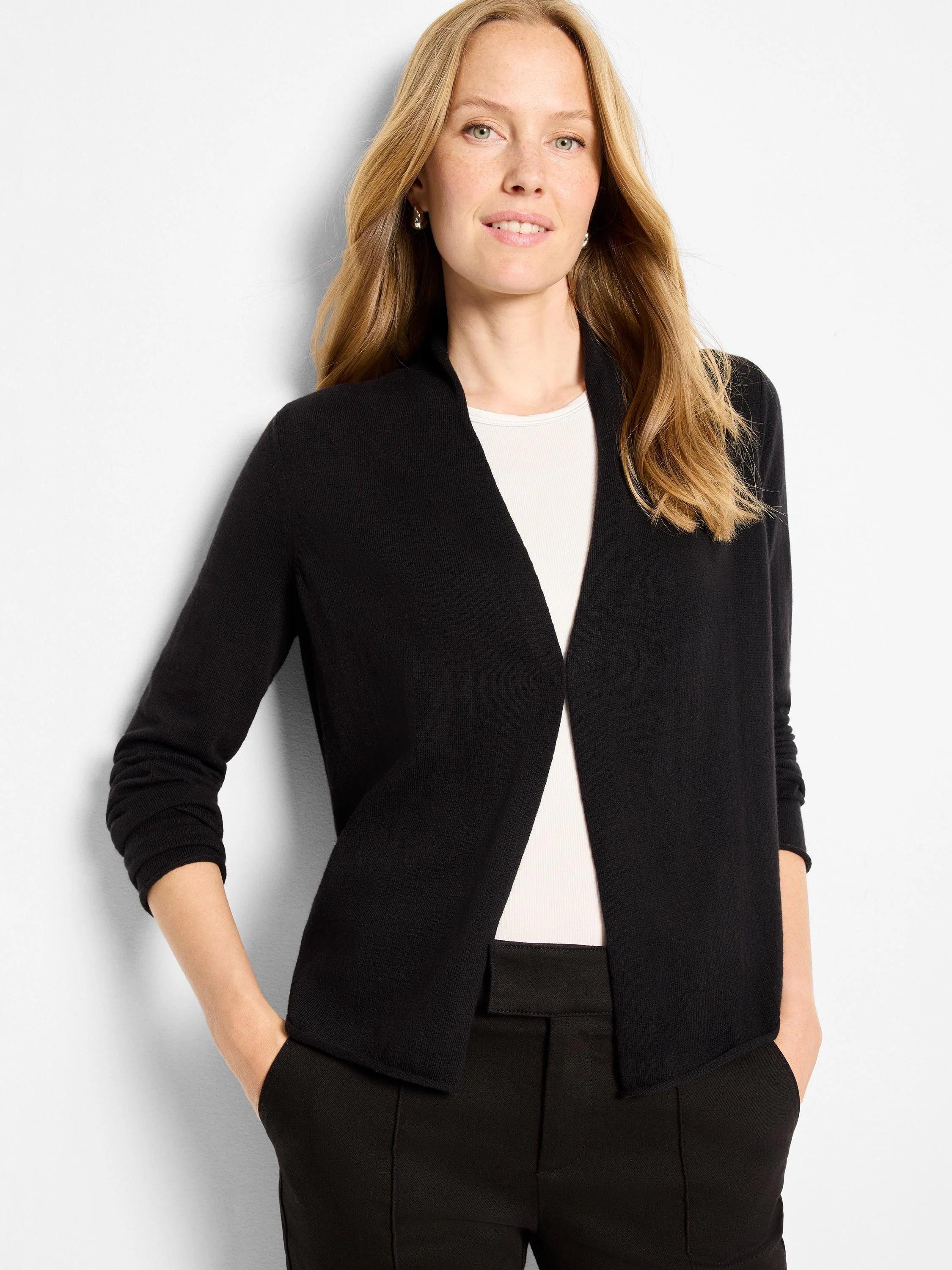 Black knit open cardigan with wide lapels and sleeves pushed up to 3/4 length.