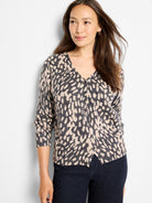 V-neck button-front sweater with irregular light beige dots on a dark gray base.